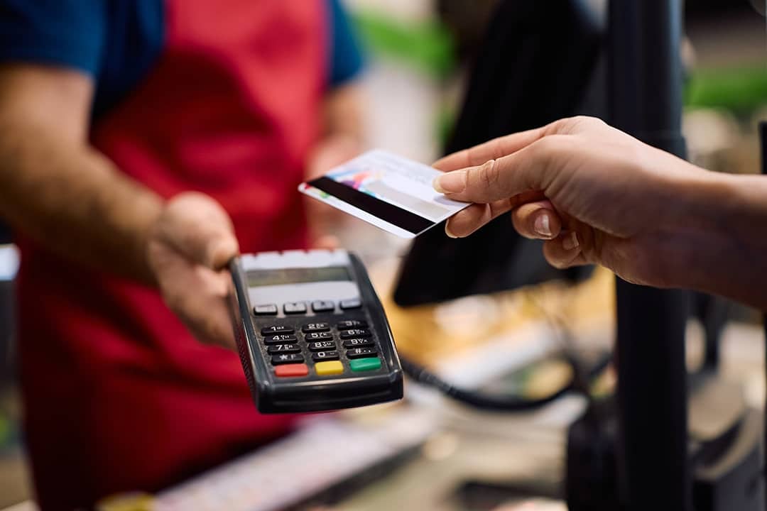 Customer paying with a card at a supermarket.
